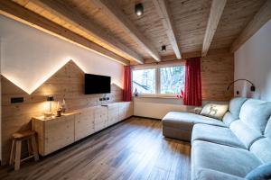 a living room with a couch and a tv at - Punta Penia - Canazei center app in Canazei