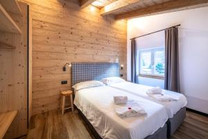 a bedroom with a large bed and a wooden wall at - Punta Penia - Canazei center app in Canazei