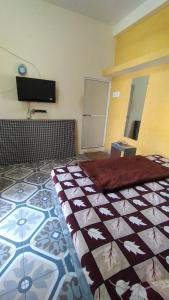 a bedroom with a bed and a tv on the wall at Shikhar guest house 1 in Ujjain +7 photos