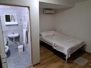 een kleine ziekenhuiskamer met een bed en een wastafel bij Hostel Lalinac in Lalince