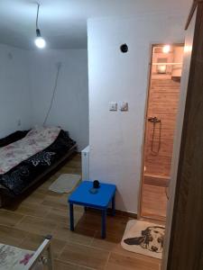 een kleine kamer met een bed en een blauwe tafel bij Hostel Lalinac in Lalince