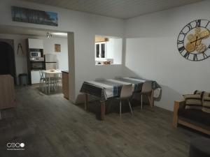 een kamer met een tafel en stoelen en een klok aan de muur bij Castorette, au calme, petit déjeuner compris in Mimizan