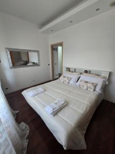 a large white bed in a bedroom with a mirror at Narni Come a casa dei nonni in Fiaiola