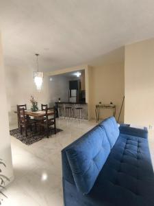 een woonkamer met een blauwe bank en een tafel bij Casa da Hellen in Porto Seguro