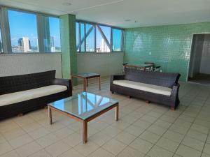 a lobby with couches and a table and windows at Bussines Flat Iguatemi in Salvador +18 photos