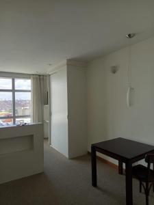 a living room with a table and a window at Bussines Flat Iguatemi in Salvador
