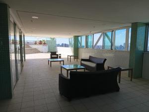 a lobby with chairs and tables in a building at Bussines Flat Iguatemi in Salvador