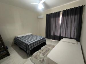 een slaapkamer met twee bedden en een raam bij Casa da Hellen in Porto Seguro +29 foto's