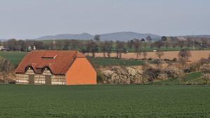 een oranje schuur in een groen grasveld bij Monteur- oder Wandererwohnung im Hildesheimer Wald in Diekholzen +4 foto's