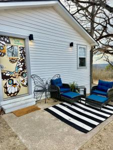 a patio with two chairs and a butterfly window at The Wing - luxurious king suite tiny studio home! in Eureka Springs
