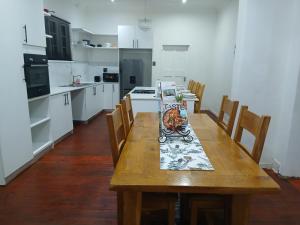 een keuken met een houten tafel en houten stoelen bij Jacaranda Escape in Pretoria +11 foto's