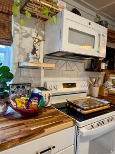 a kitchen with a microwave and a stove top oven at The Wing - luxurious king suite tiny studio home! in Eureka Springs