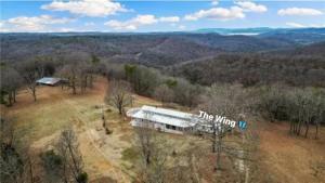 an aerial view of a house in a field at The Wing - luxurious king suite tiny studio home! in Eureka Springs
