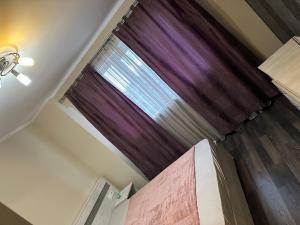 a bedroom with a window with purple curtains at Republicii Central in Ploieşti