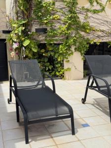 twee zwarte stoelen op een tegelterras bij Hotel Germânia in Joinville