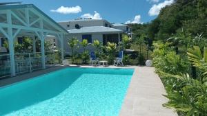 a villa with a swimming pool and a house at LE DOMAINE de L'HYLODE in Sainte-Anne