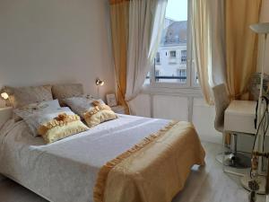 a bedroom with a bed with pillows and a window at Chambres chez l'habitant in Meudon +4 photos