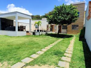 a yard with a tree and a house at Casa em São Mateus - Guriri in São Mateus