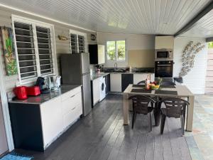a large kitchen with a table and chairs in it at VILLA COLIBRI Piscine balnéo privative in Sainte-Rose