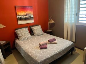 a bedroom with a bed with two towels on it at VILLA COLIBRI Piscine balnéo privative in Sainte-Rose