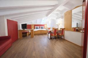a living room with a bed and a table and chairs at Hotel Comfort Erica Dolomiti Val d'Adige in Salorno sulla Strada del Vino