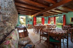 a restaurant with tables and chairs and a stone wall at B&B Casale Onida in Volta Mantovana