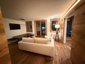 a living room with a white couch and a table at Sky nest - Matterhorn in Breuil-Cervinia