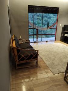 een bank in een kamer met een groot raam bij Chalé Freital in Nazaré Paulista