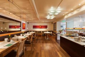 een restaurant met houten tafels en stoelen en een bar bij Hotel Germania in Bregenz