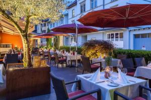een restaurant met tafels, stoelen en parasols bij Hotel Germania in Bregenz