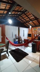 een rode hangmat in een kamer met een tafel en stoelen bij Casa Vargem Pequena in Florianópolis