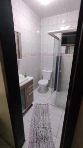 een badkamer met een douche, een toilet en een tapijt bij Casa Vargem Pequena in Florianópolis +25 foto's