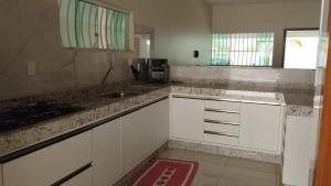 una cucina con mobili bianchi e un lavandino di CASA 400 m DA PRAIA 3 QUARTOS GURIRI NORTE a São Mateus