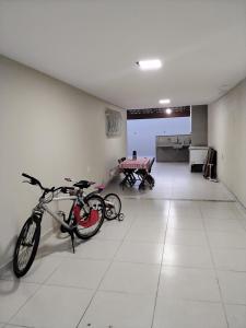 una bicicletta parcheggiata in una stanza con tavolo di CASA 400 m DA PRAIA 3 QUARTOS GURIRI NORTE a São Mateus