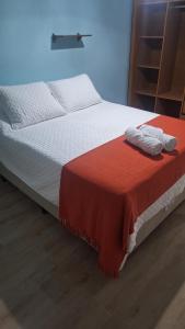 a bed with a red and white blanket on it at Apartamento charme in Marechal Deodoro
