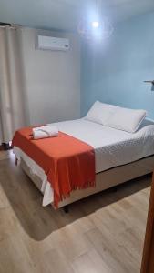 a bedroom with a bed with a red blanket on it at Apartamento charme in Marechal Deodoro