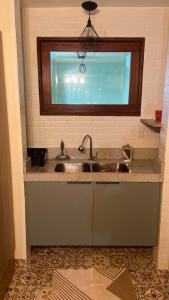 a kitchen counter with a sink and a window at Apartamento charme in Marechal Deodoro