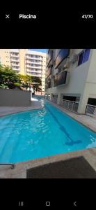 a large blue swimming pool next to a building at Best Residence in Rio de Janeiro