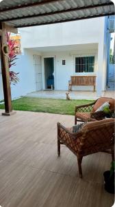 a patio with a couch and a bench and a building at Suíte Peroba em Maragogi in Maragogi