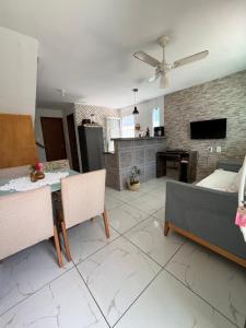 a kitchen and living room with a table and a couch at Suíte Peroba em Maragogi in Maragogi