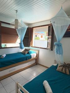 a bedroom with two beds and a window at Villa JOSAMY Charmante Villa avec Piscine à Deux Pas de la Mer in Sainte-Luce +18 photos