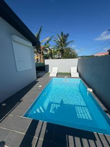 een zwembad aan de zijkant van een huis bij Villa JOSAMY Charmante Villa avec Piscine à Deux Pas de la Mer in Sainte-Luce