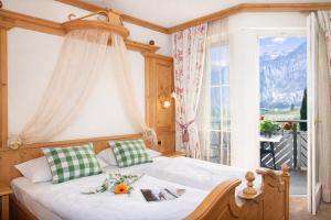 a bedroom with a bed and a large window at Hotel Comfort Erica Dolomiti Val d'Adige in Salorno