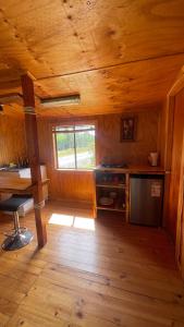 een keuken in een blokhut met een fornuis en een raam bij Cabañas Kuela in Puerto Varas