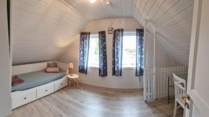 een kleine slaapkamer met een bed en twee ramen bij Cozy Cottage 