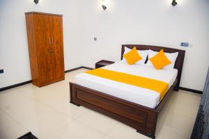 een slaapkamer met een bed met oranje en gele kussens bij Elevate Villa Galle in Galle
