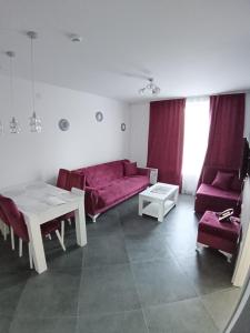 un soggiorno con un divano rosso e un tavolo di Wolf Apartments Kopaonik a Kopaonik