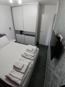 una camera da letto con un letto con asciugamani sopra di Wolf Apartments Kopaonik a Kopaonik