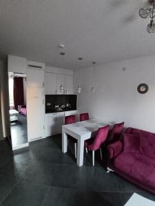 un soggiorno con tavolo e divano viola di Wolf Apartments Kopaonik a Kopaonik Altre 44 foto