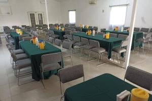 een kamer met groene tafels en stoelen in een klaslokaal bij Zar Guadalajara in Guadalajara